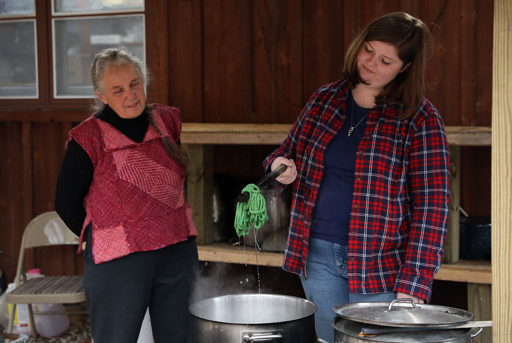 Allison Potter checks to see if a wool loop is dyed green